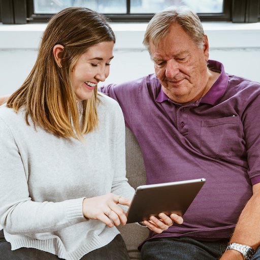 Two people look over data on a tablet