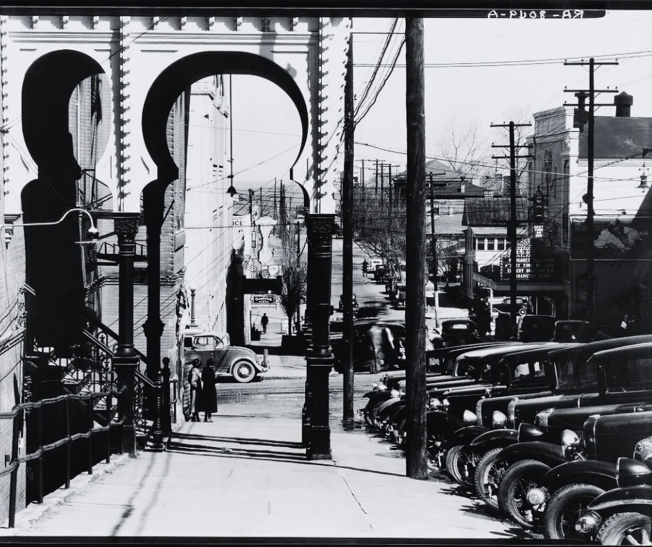 Black and white photo of sidewalk and cars